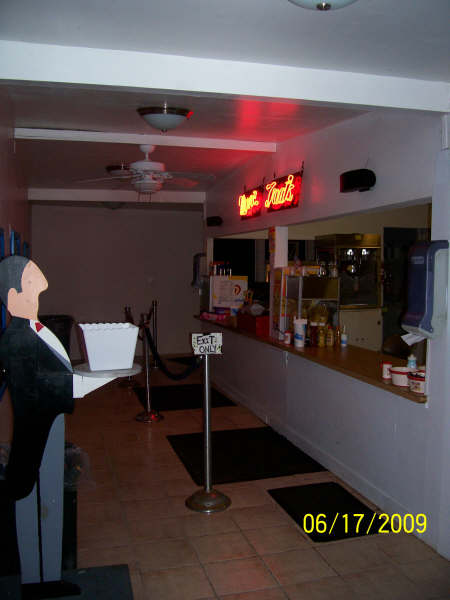 Inside the Finger Lakes Drive-In concession stand, with the "Concessions & Treats" neon sign glowing over the counter